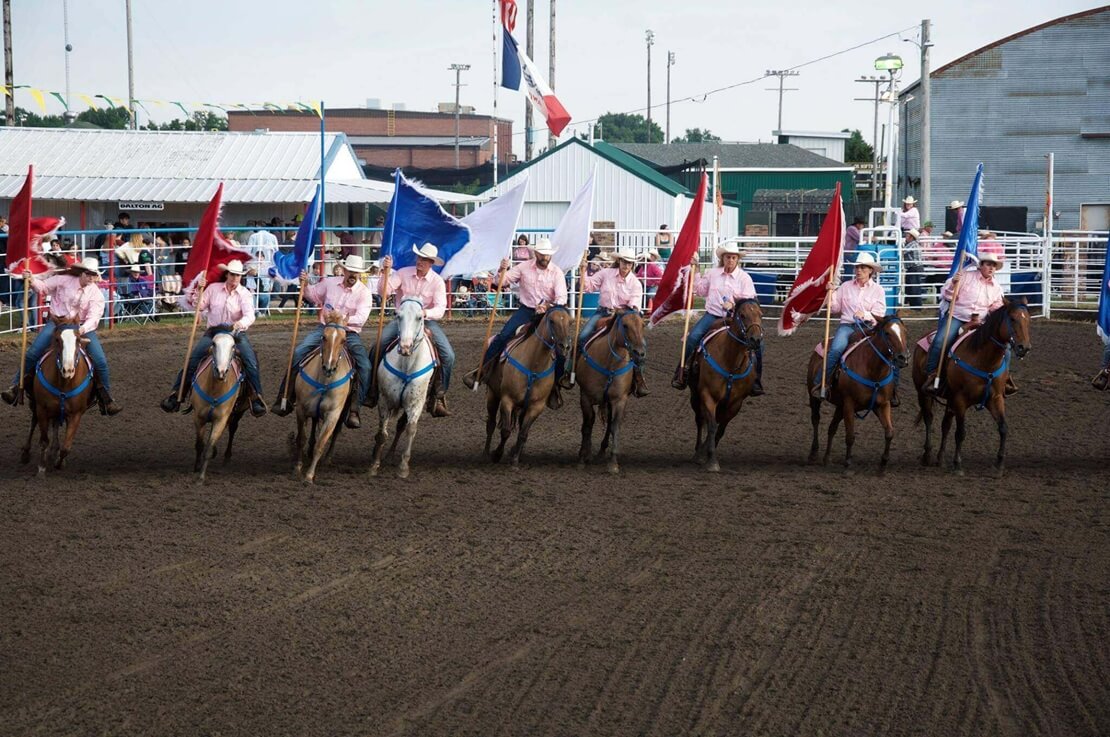 Lenox Rodeo Team carrying flags on horses